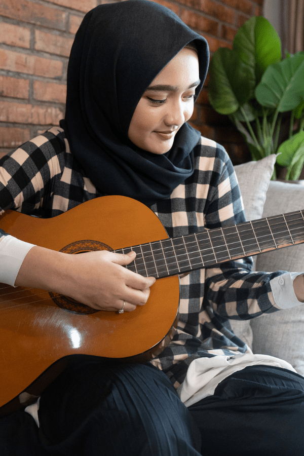 A person strumming an acoustic guitar.